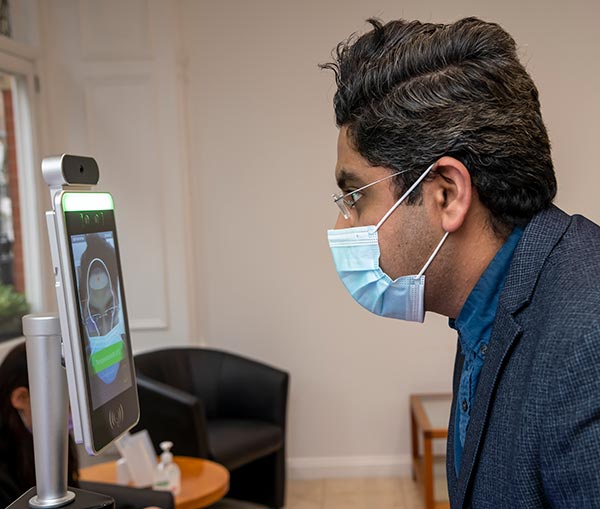 Examining patient through heat sensor for temperature