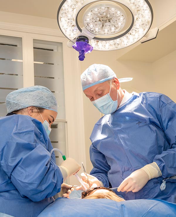 Consultant Mr Luke Cascarini examining patients mouth with nurse