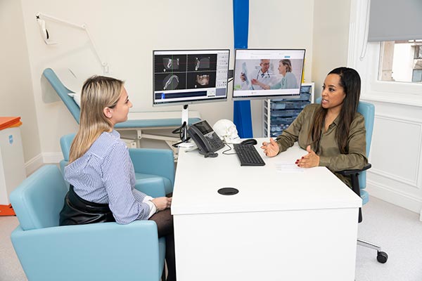 HSSH consultant Natasha Berridge at desk with a patient