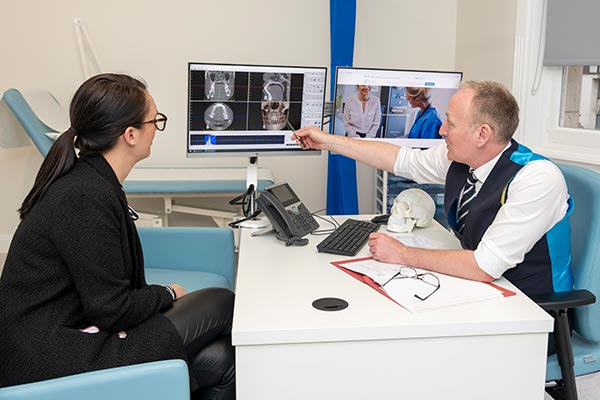 Mr Luke Cascarini showing a patient their xray at an HSSH consulting room