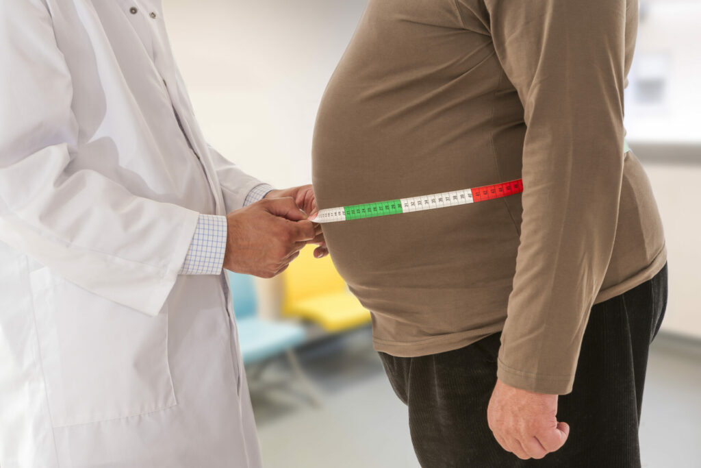 doctor measuring obese man's waist