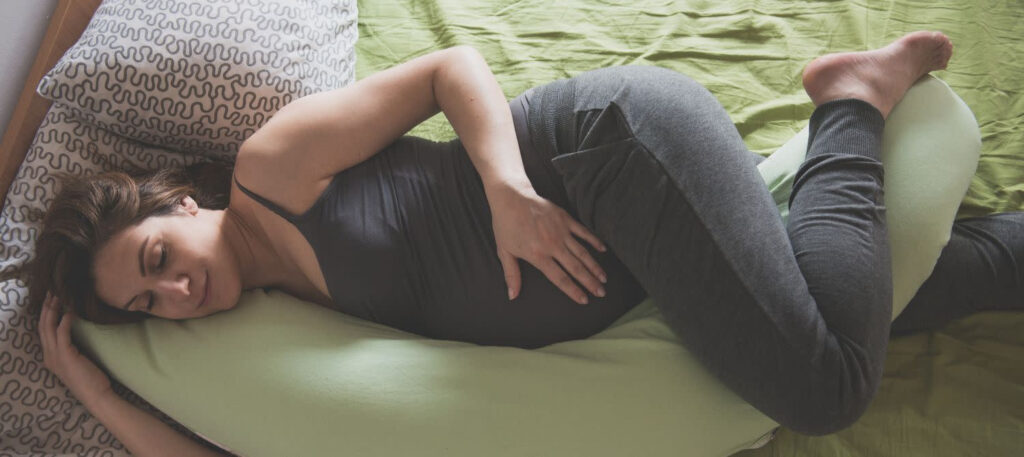 pregnant woman sleeping in bed