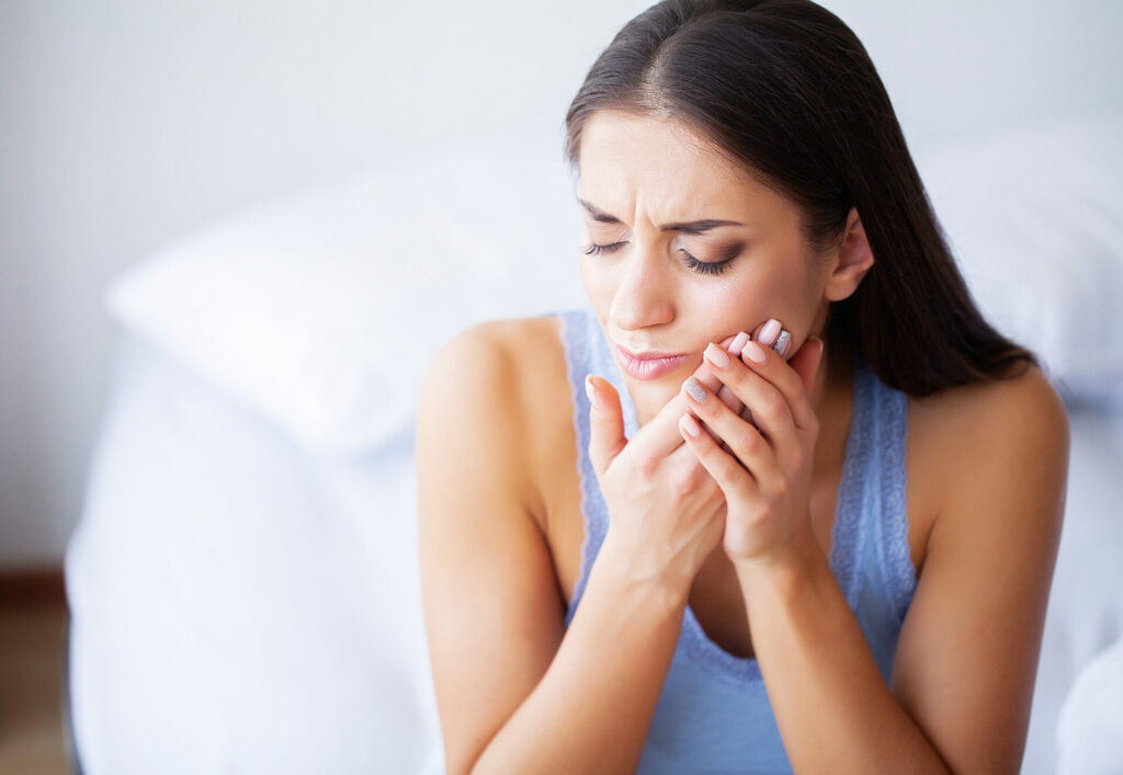 woman clutching her jaw in pain